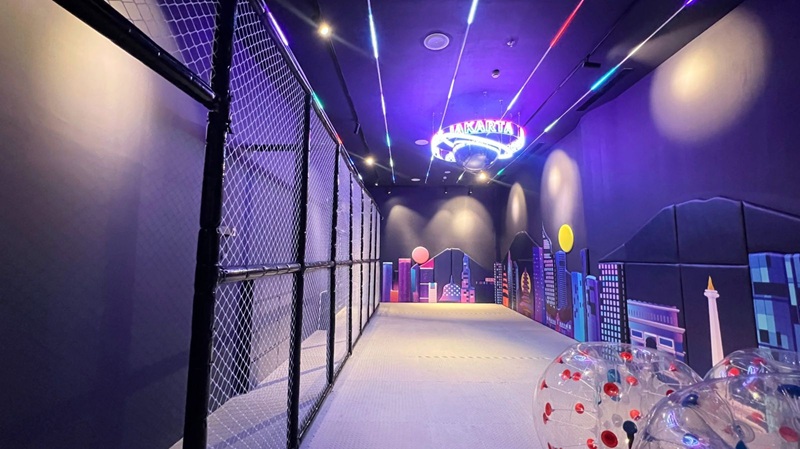 Neon-lit hologram corridor with colorful futuristic city skyline projections and a clear bubble obstacle course wall