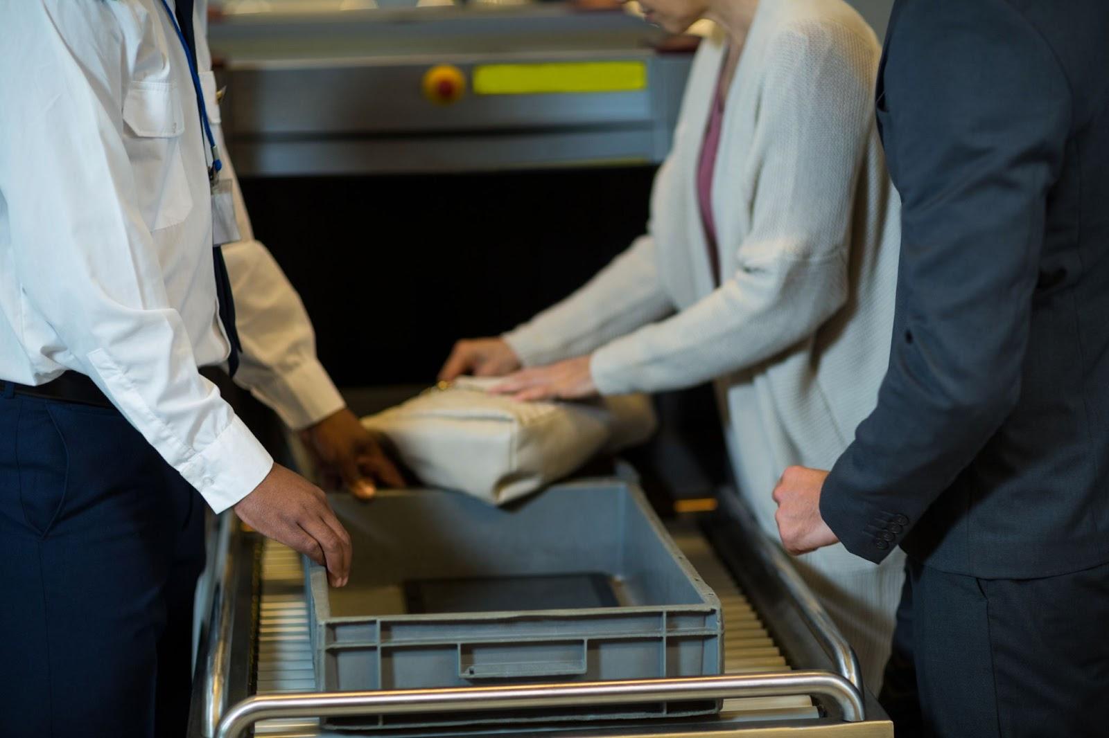 Healthcare workers in uniforms handling boxed supplies on a cart in a hospital setting