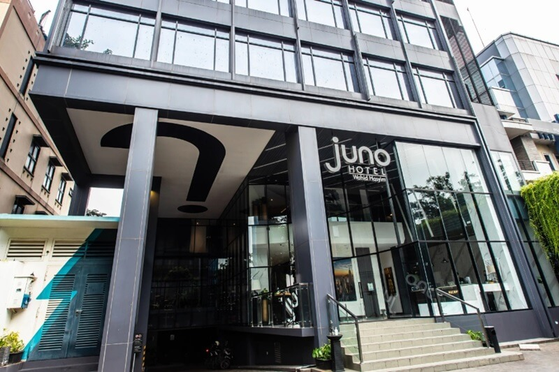 Juno Hotel exterior entrance with glass facade and signage on a city building