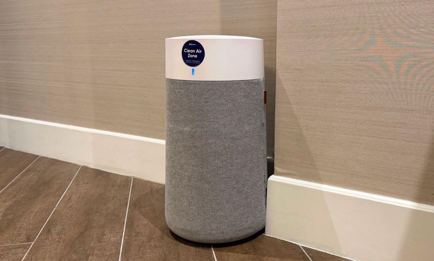 Clean Air Zone air purifier tower with indicator light on grey fabric filter standing on tiled floor