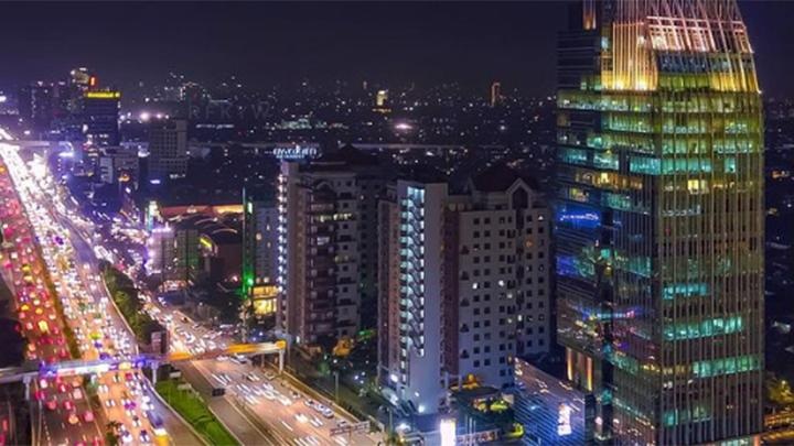Nighttime city skyline with illuminated streets and high-rise buildings, urban traffic and glowing facades