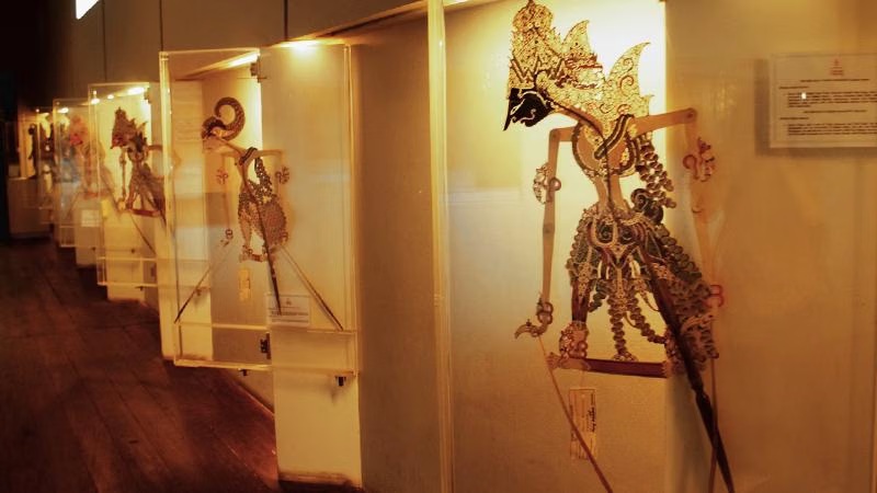 Ornate bronze weapon sculpture with dragon figure in museum glass display case along corridor