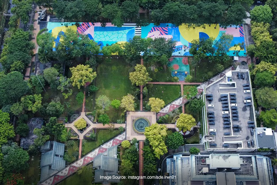 aerial top view of a city park with colorful mural art and parking