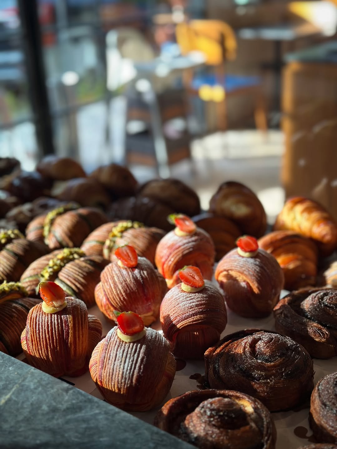 assorted fresh pastries with strawberry toppings in a bakery