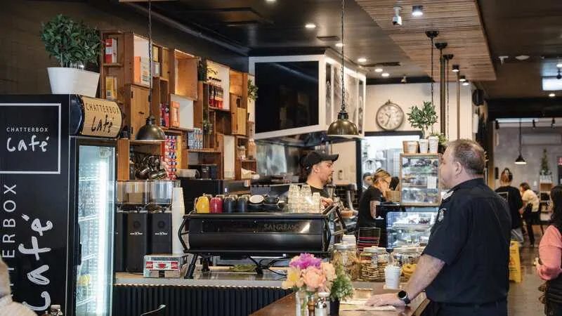 busy cafe counter with espresso machine barista and shelves