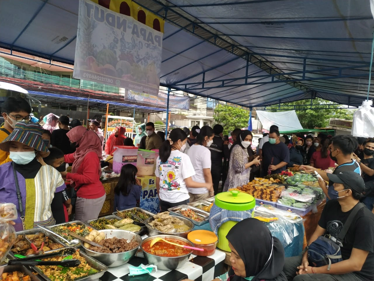 busy outdoor food market stall with various indonesian dishes