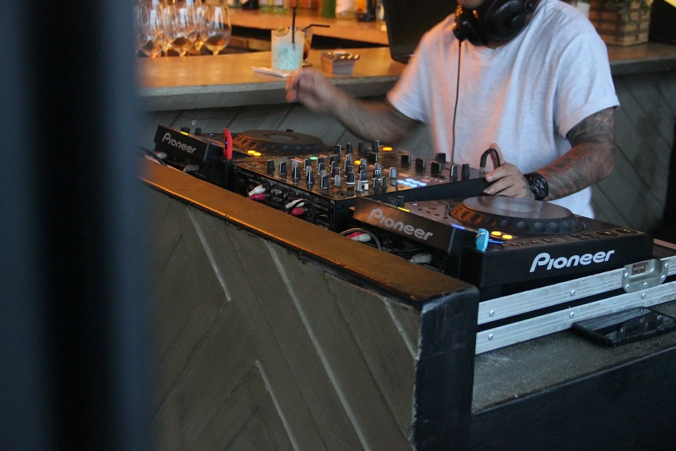dj mixing music on pioneer decks at a venue bar