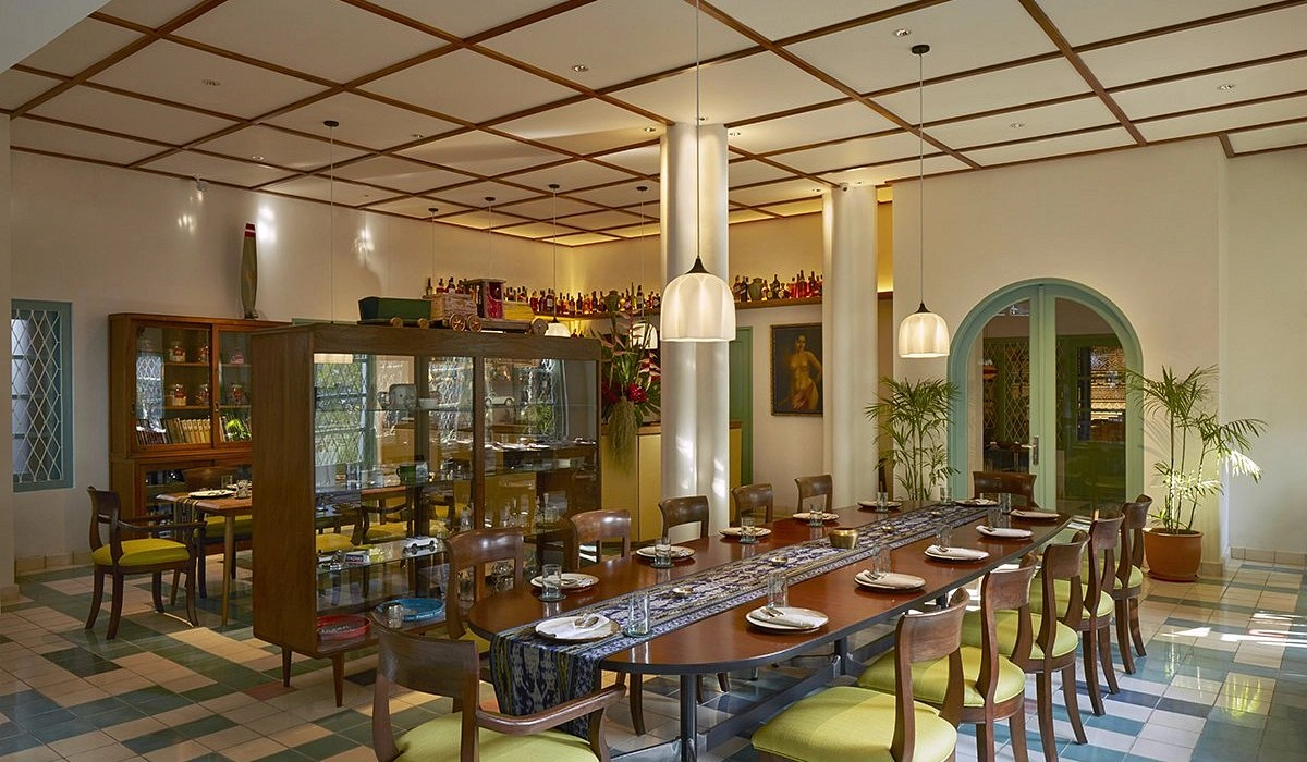 elegant dining room interior with long wooden table green chairs and pendant lights