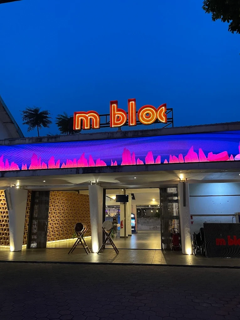 entrance of m bloc space with glowing red neon sign at dusk