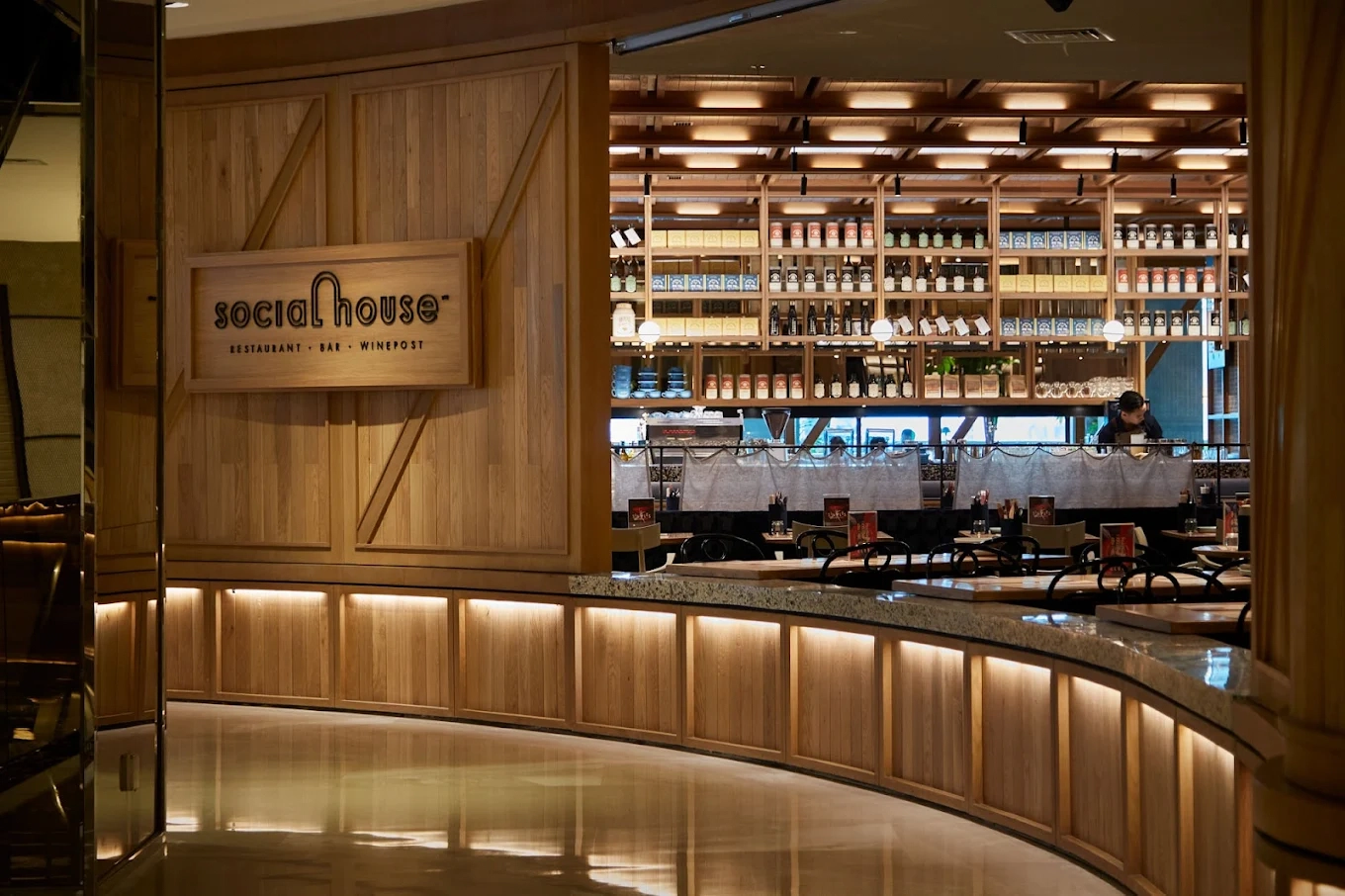 entrance of social house restaurant bar with warm wooden interior lighting