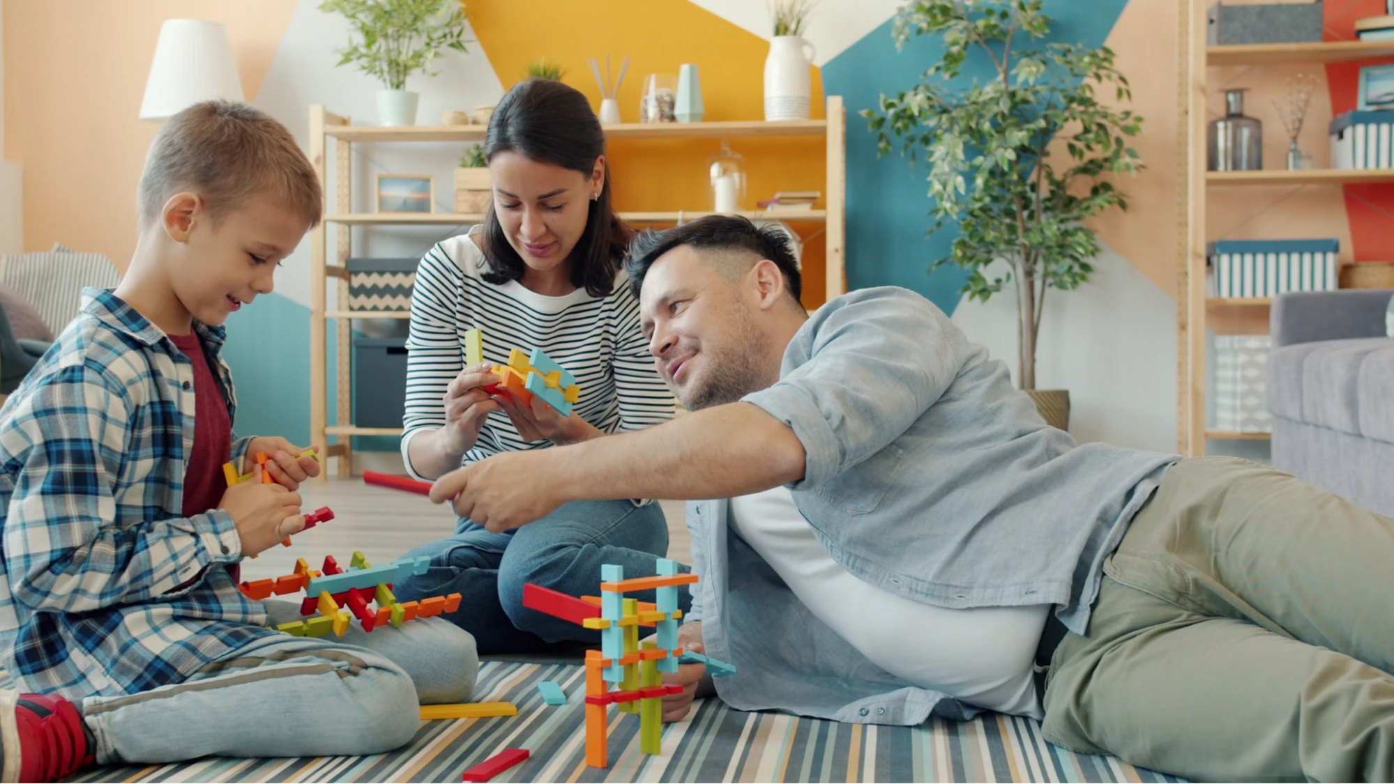 family playing with colorful toy blocks on living room floor