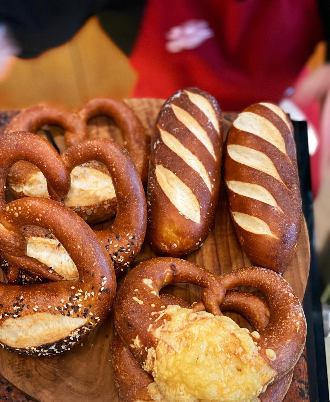 freshly baked pretzels and rolls on a wooden tray