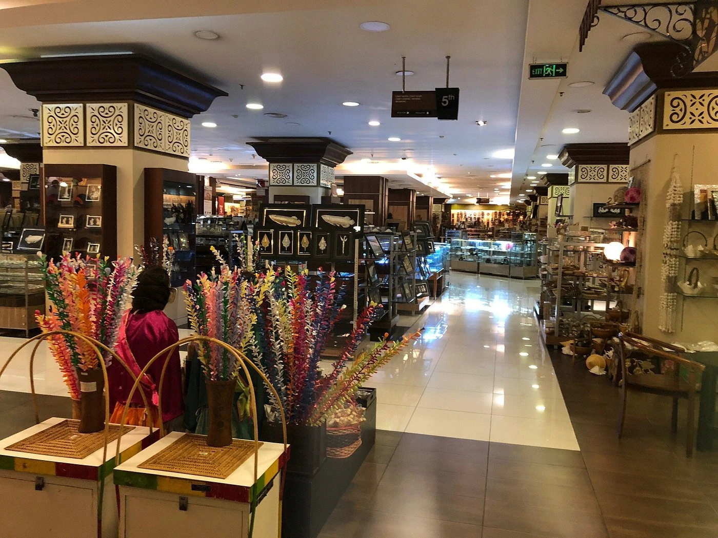 indoor handicraft market corridor filled with colorful souvenir displays and stalls