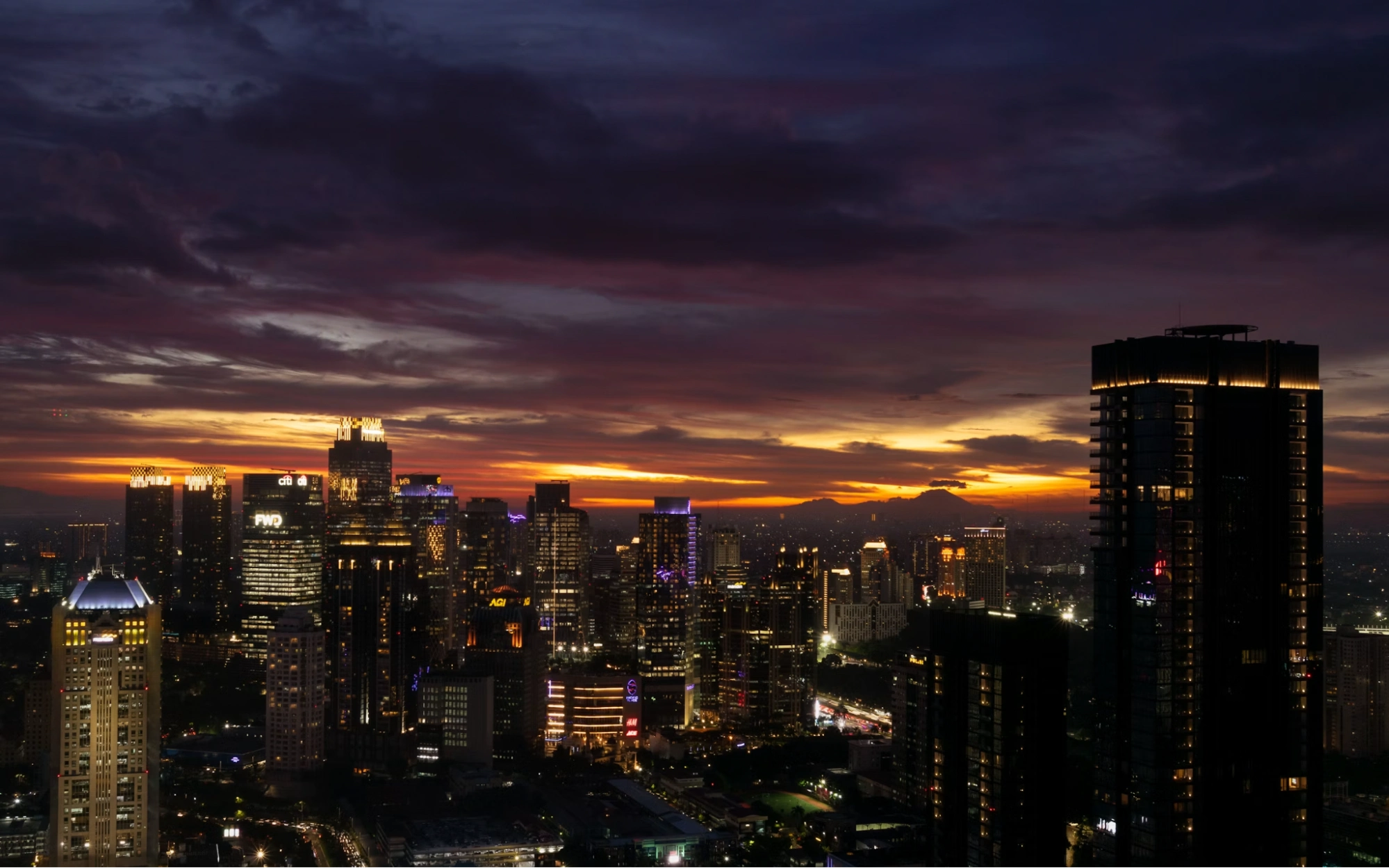 jakarta skyline at dusk with dramatic orange sunset