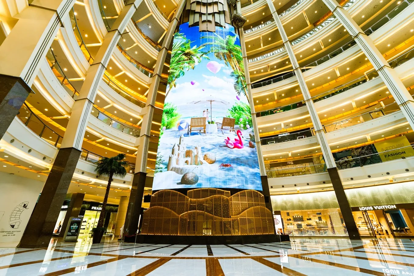 large curved digital display screen in the atrium of a luxury shopping mall
