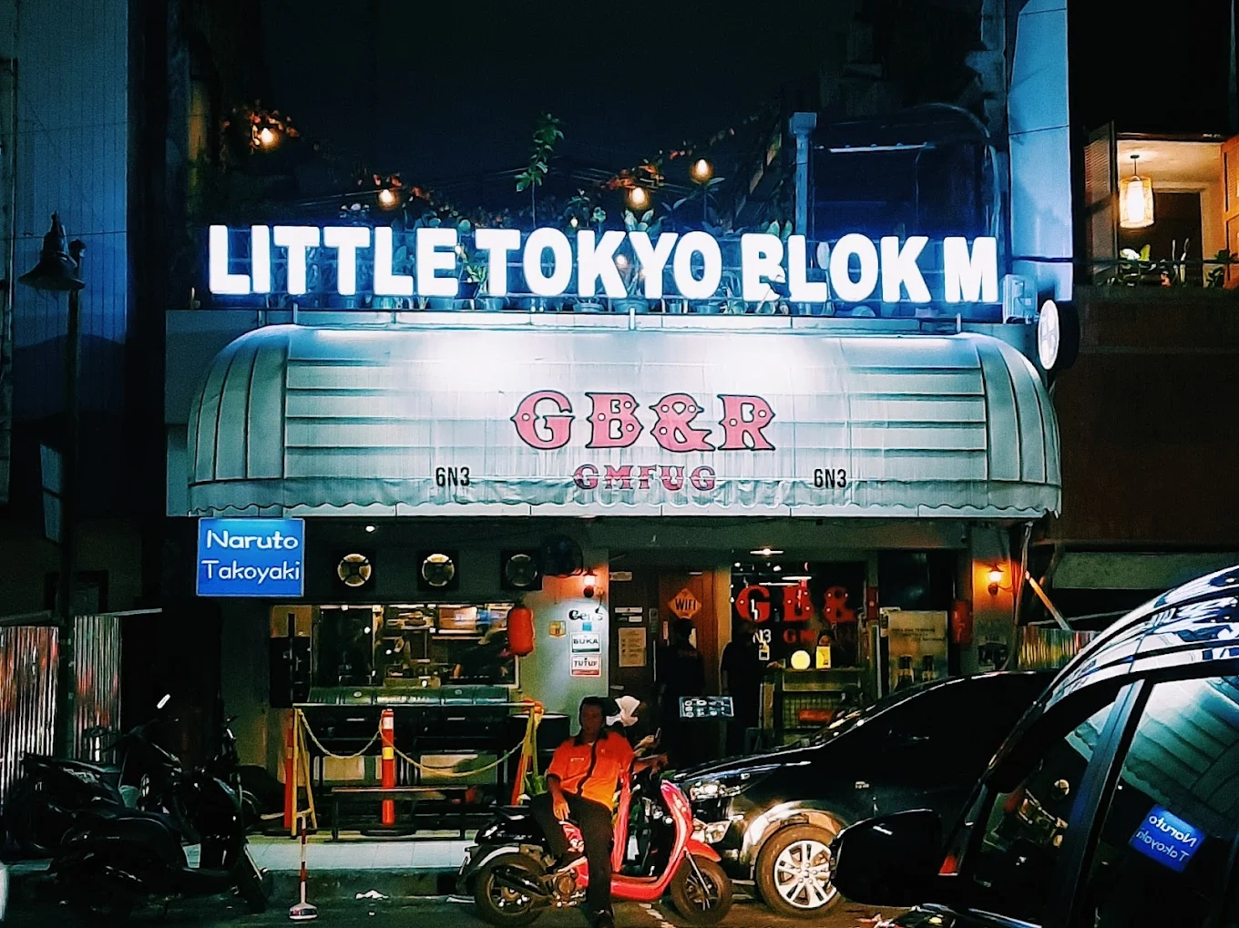 little tokyo blok m shop front lit up at night with motorbikes parked