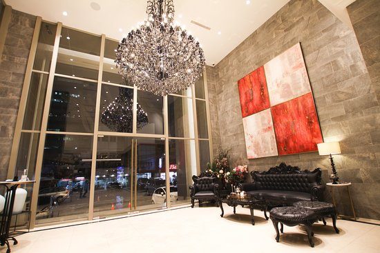luxury lobby with a large crystal chandelier and black leather sofa