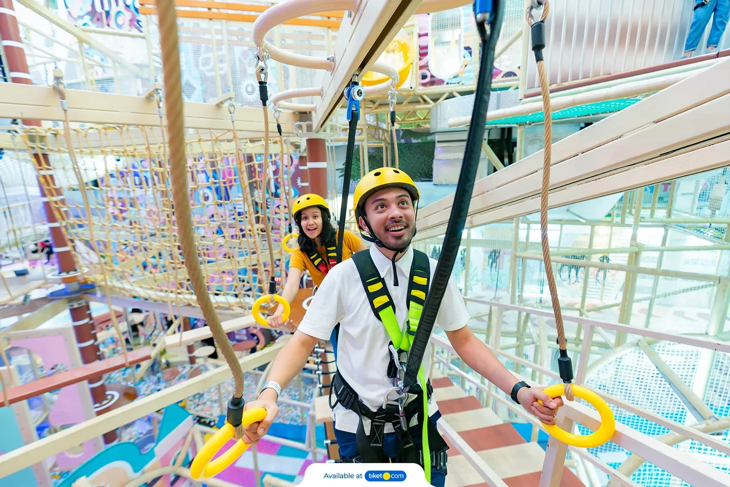 man and woman navigating indoor obstacle course on ropes