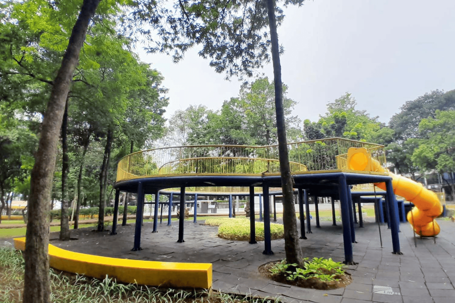 modern playground with a circular platform and yellow slide