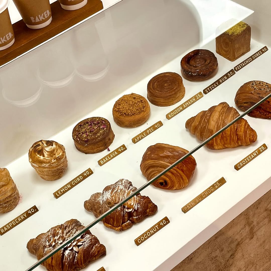 neatly arranged pastries and prices behind a glass display