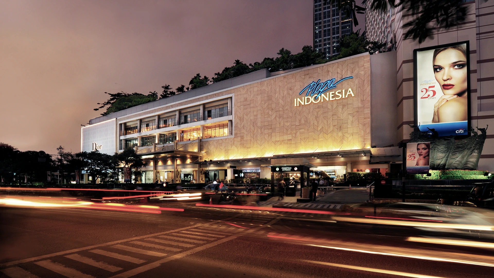 plaza indonesia mall at night with glowing lights and billboards