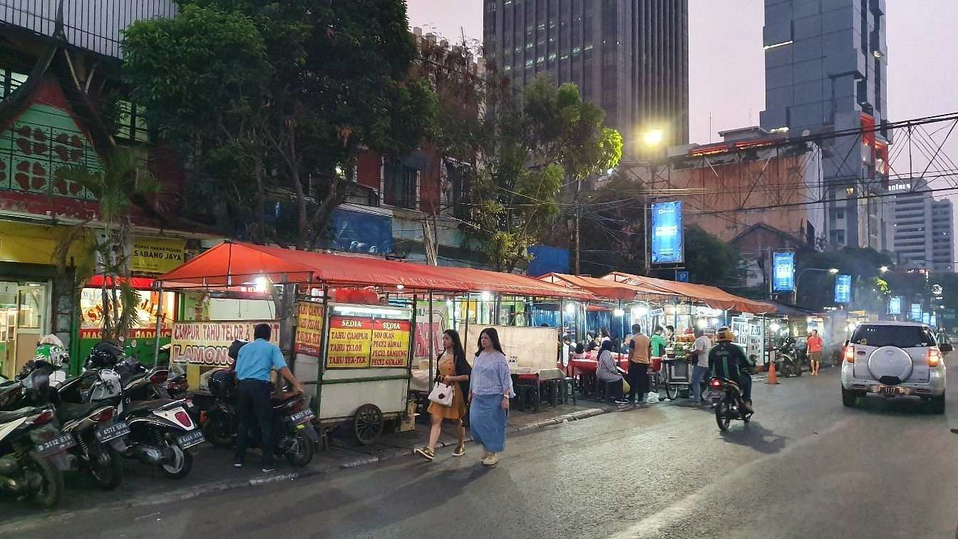 row of street food tents along sabang street in jakarta at dusk