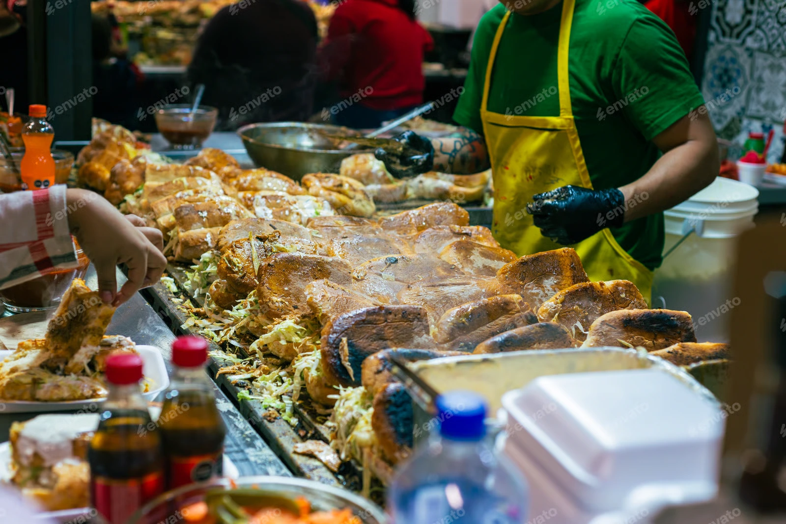 street food stall vendor preparing tortas on a large flat top grill
