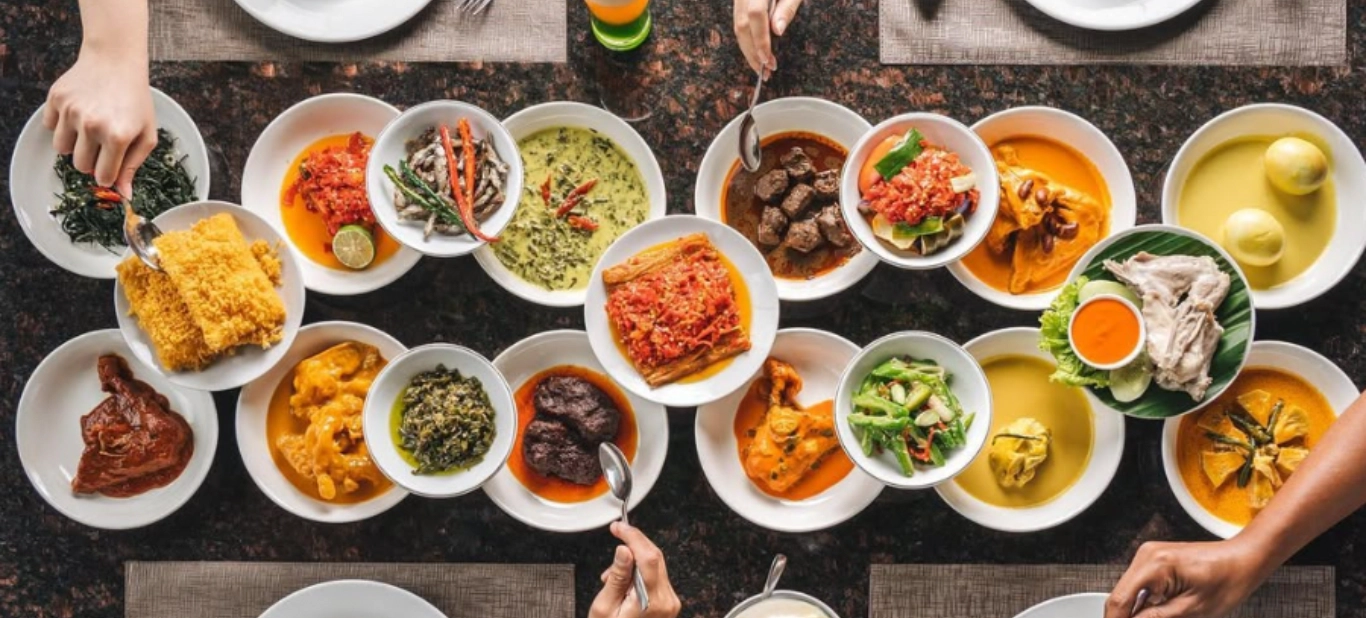 top-down view of table filled with a spread of traditional padang dishes
