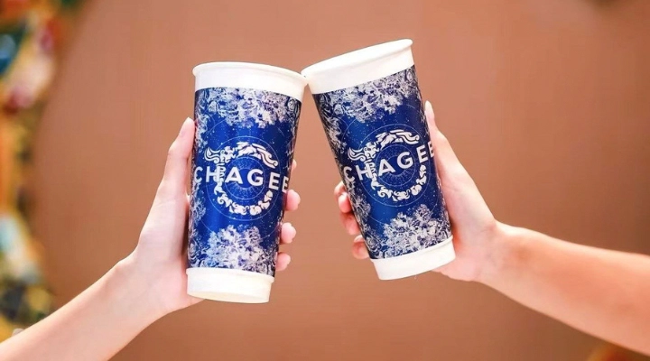 two people toasting blue and white patterned chagee paper tea cups